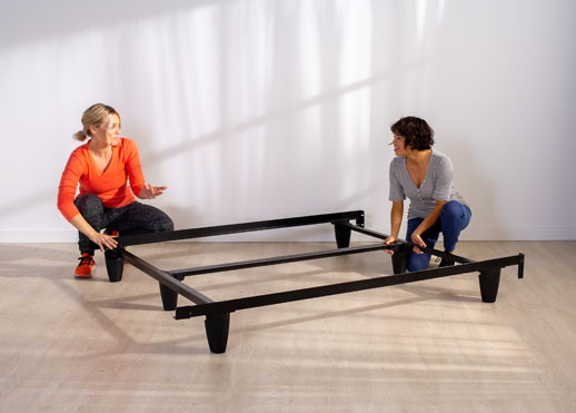 Two woman putting the bed frame together