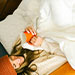 Woman drinking coffee under a white comforter