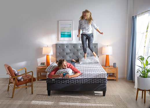 Woman jumping on a mattress on a platform bed frame
